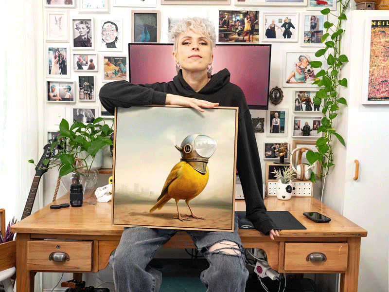 Artist Lix North with her dystopian canary oil painting 'Seer', now featured on the cover of 'Weridscapes - An Otherworldly Anthology' by Ink Alchemy Books